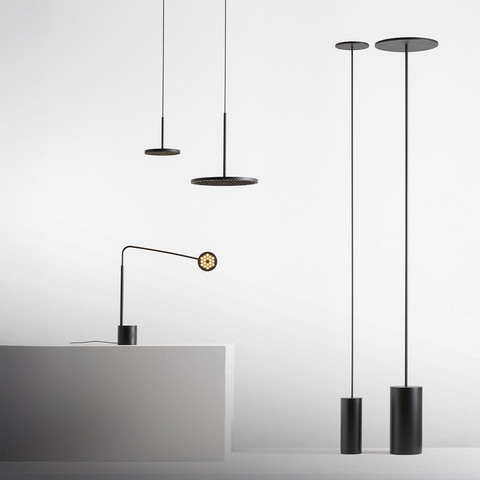 Artemide Helgoland collection: black pendant lamps with flat disc shades, a table lamp with articulated arm, and floor lamps with cylindrical bases