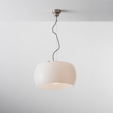Artemide Omega pendant lamp with wide rounded white opal diffuser suspended by a black cord from a brushed metal ceiling rose