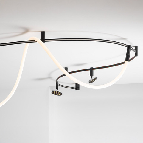 Artemide Sylt ceiling system: dark metal track with sinuous white LED neon tube and two adjustable spotlights mounted on ceiling