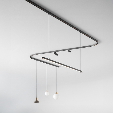 Artemide Turn Around: curved dark track system on ceiling with spotlight, linear LED bar, and three pendant lights including globe and cone shades