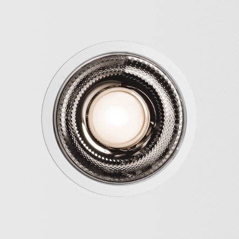 Artemide Luceri LED recessed ceiling spotlight with circular white trim and textured chrome reflector surrounding central LED source