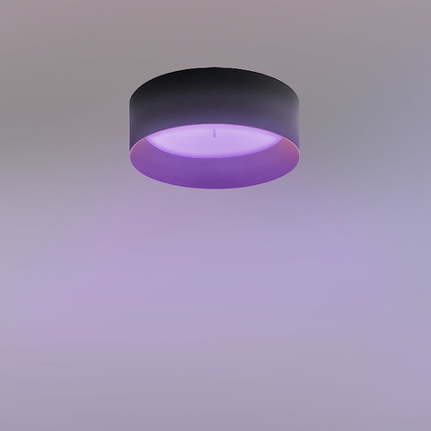 Artemide Tagora INTEGRALIS ceiling lamp with black cylindrical shade emitting a soft purple light downward