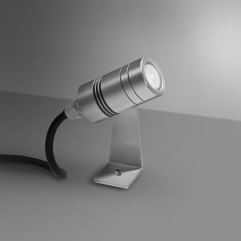 Artemide Minispot compact LED spotlight in silver aluminum, mounted on an angled bracket, emitting a focused beam of light