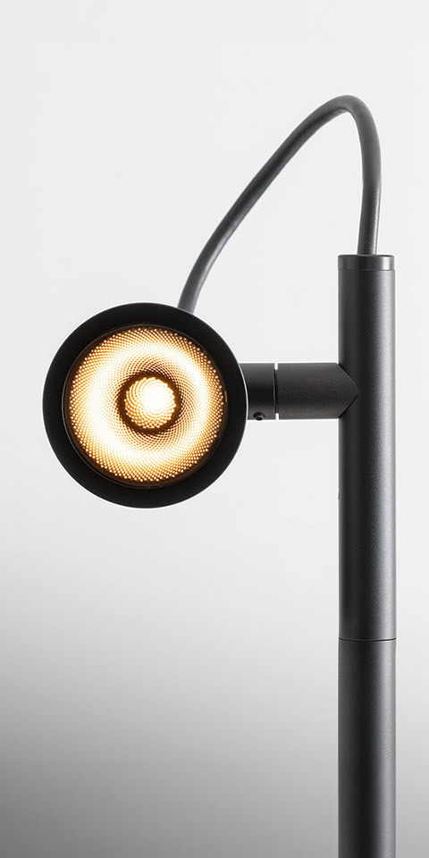 Artemide Conus floor lamp in matte black, circular LED head with concentric light rings on adjustable arm and vertical pole
