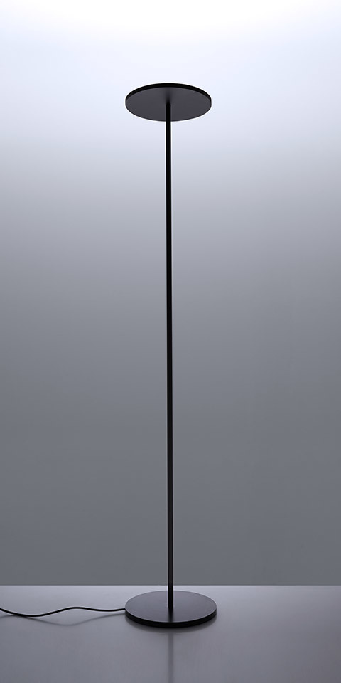 Artemide Athena INTEGRALIS floor lamp in black, featuring a slender stem, circular disc diffuser on top, and flat round base