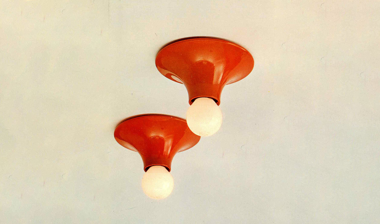 Two orange ceramic flush ceiling lights with white opal glass globe bulbs, mounted directly on a white ceiling.