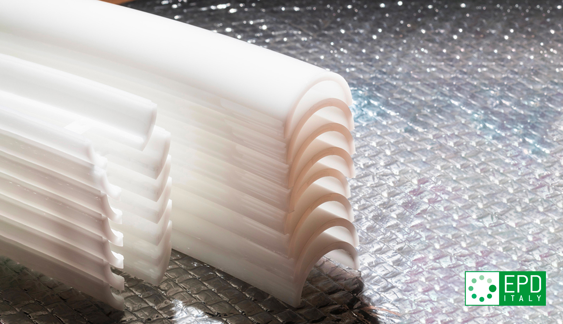 Close-up of white opal diffuser components with ribbed texture, stacked together, showing light-diffusing material used in Artemide fixtures