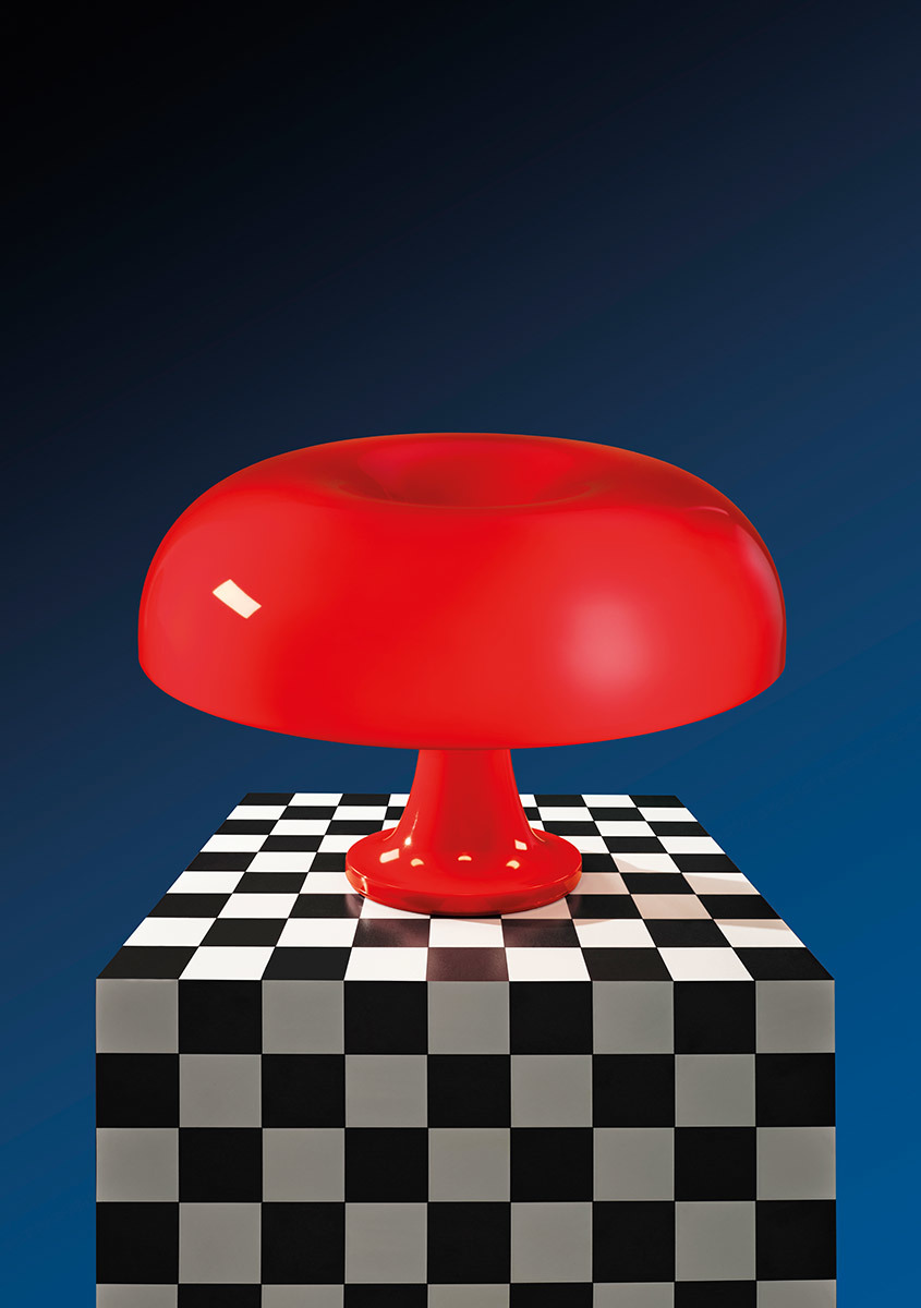 Artemide Nessino table lamp in red, with iconic mushroom-shaped shade, displayed on a black and white checkered pedestal