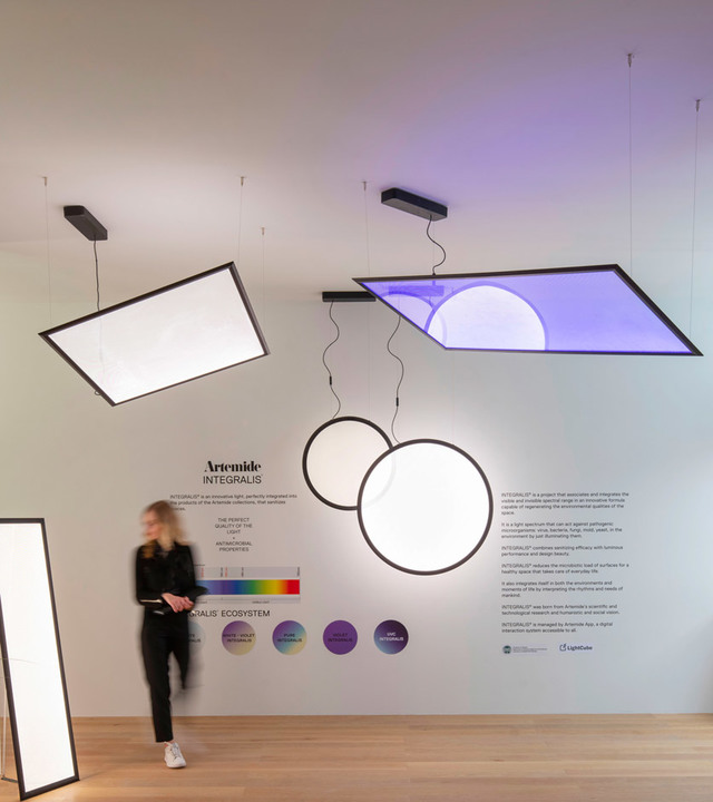 Artemide Integralis display: rectangular LED panels and circular pendant lights suspended, one emitting purple light, in a showroom.