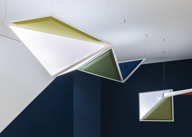 Geometric pendant lights with triangular white, yellow-green, dark green, and blue panels suspended from ceiling by thin cables