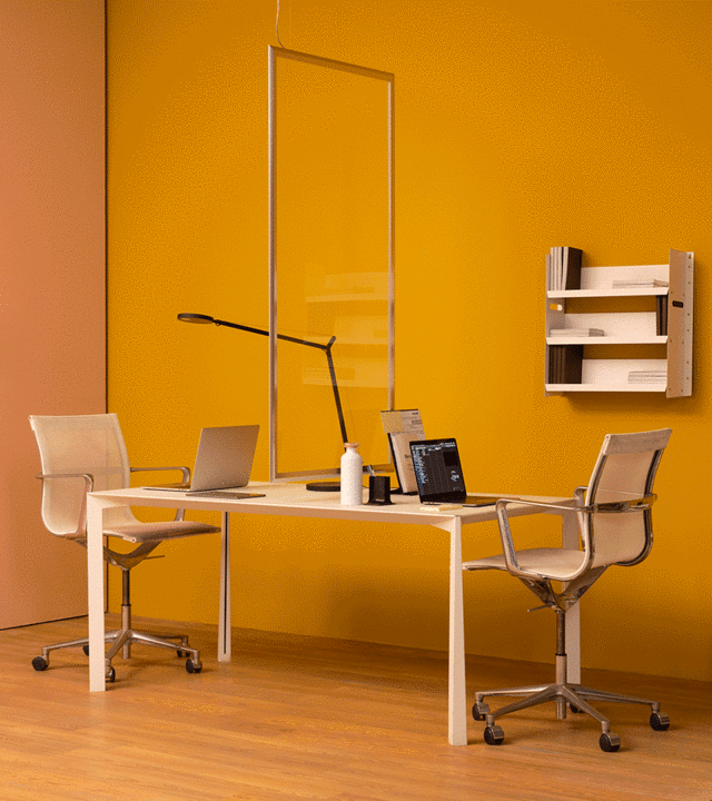 Modern office workspace with two chairs at a shared white desk, Artemide Tolomeo table lamp, and a rectangular pendant light above.