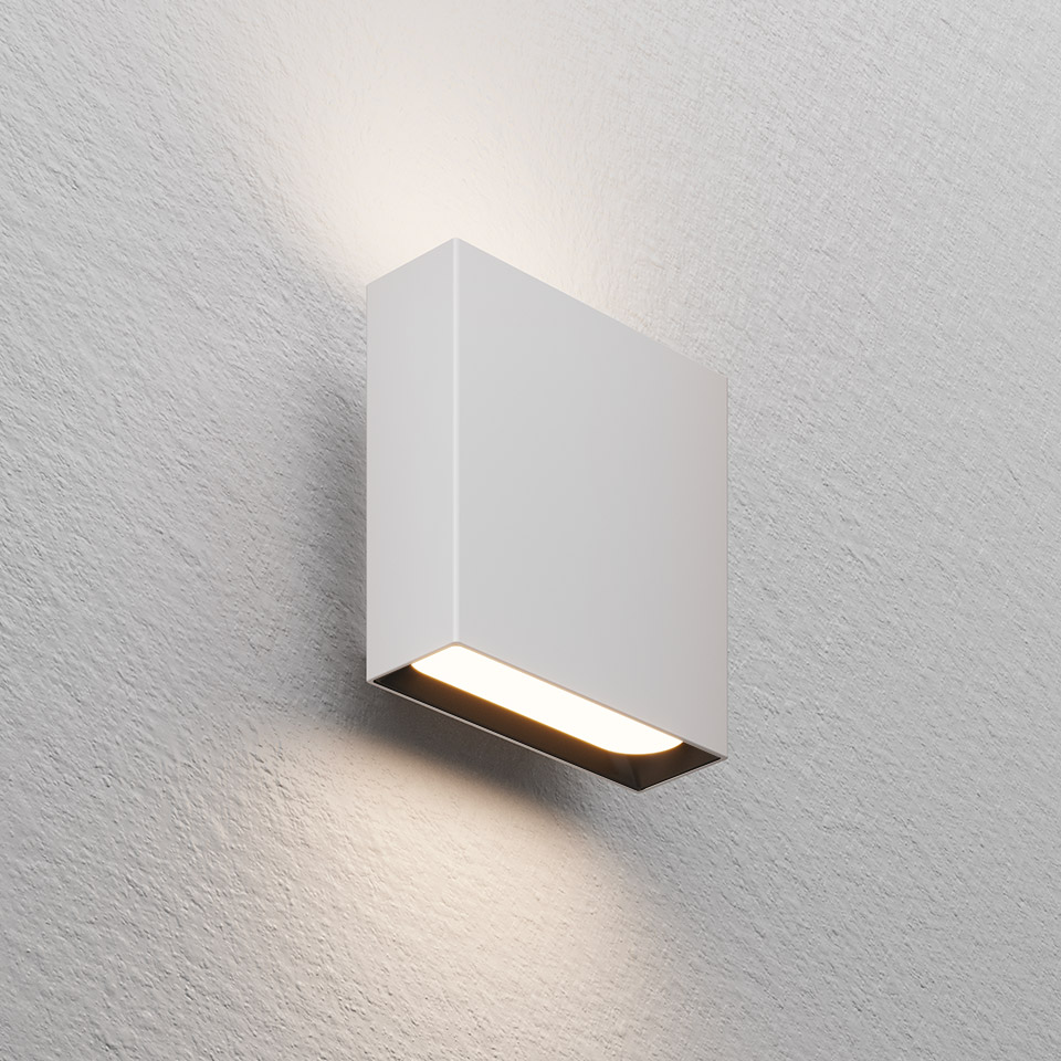 Artemide Agathe white wall light emitting warm upward and downward glow through a horizontal LED slot on textured wall