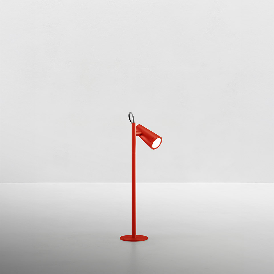 Artemide Conus table lamp in red, featuring a slim stem, circular base, adjustable cylindrical LED spotlight head, and a small ring detail