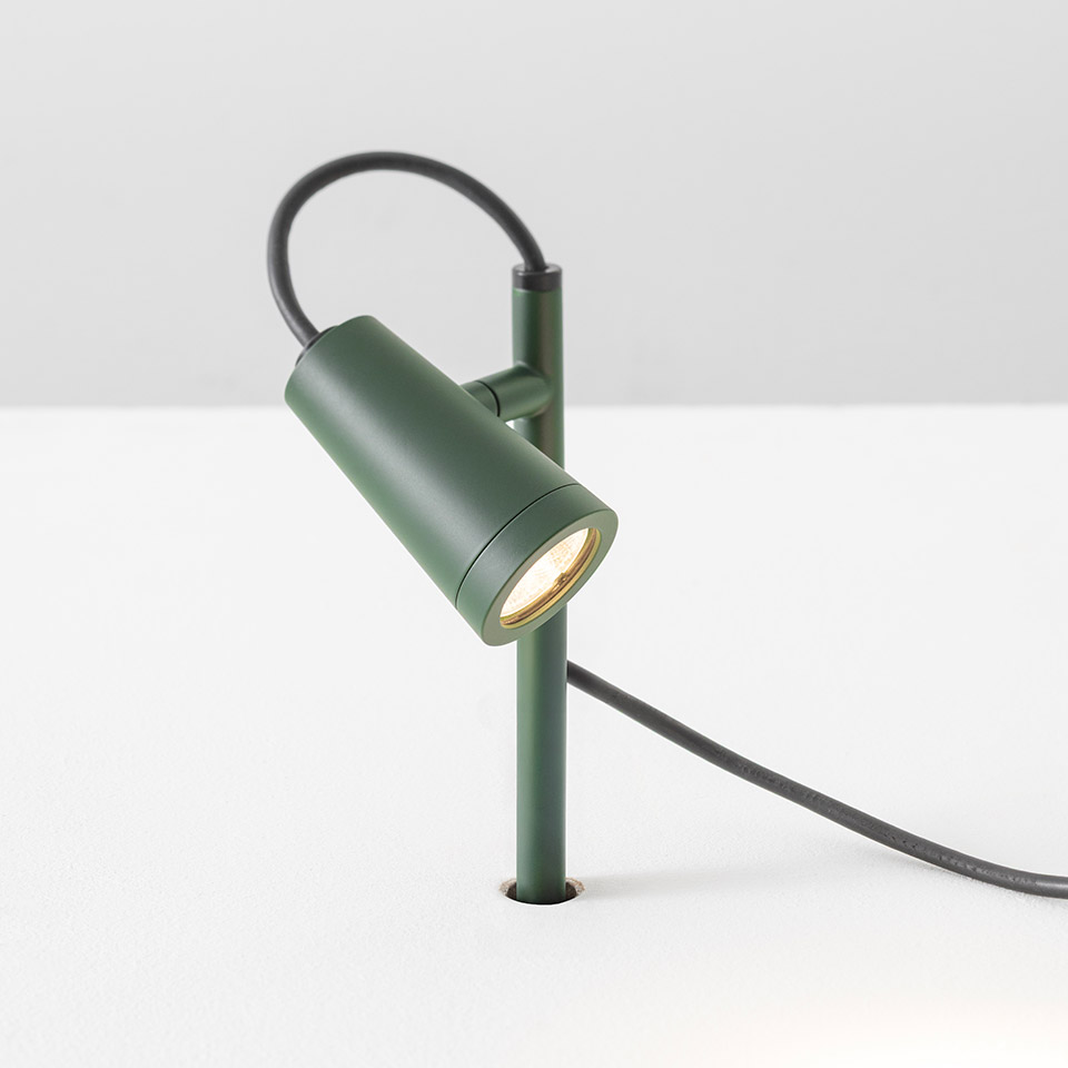 Artemide Conus table spotlight in matte green, cylindrical adjustable head on slim stem with dark power cord
