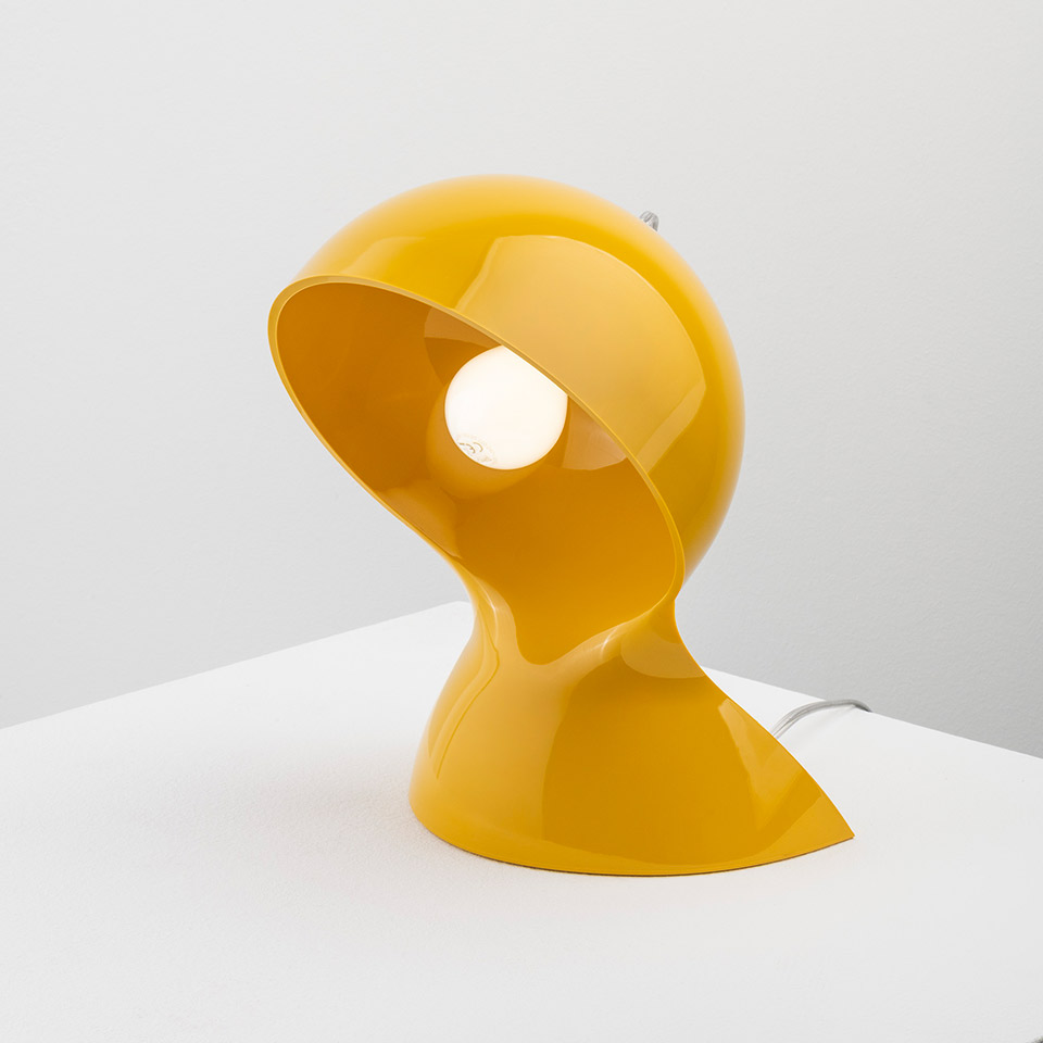 Artemide Dalù table lamp in glossy yellow, featuring a spherical rotating shade on a curved base, with exposed bulb visible