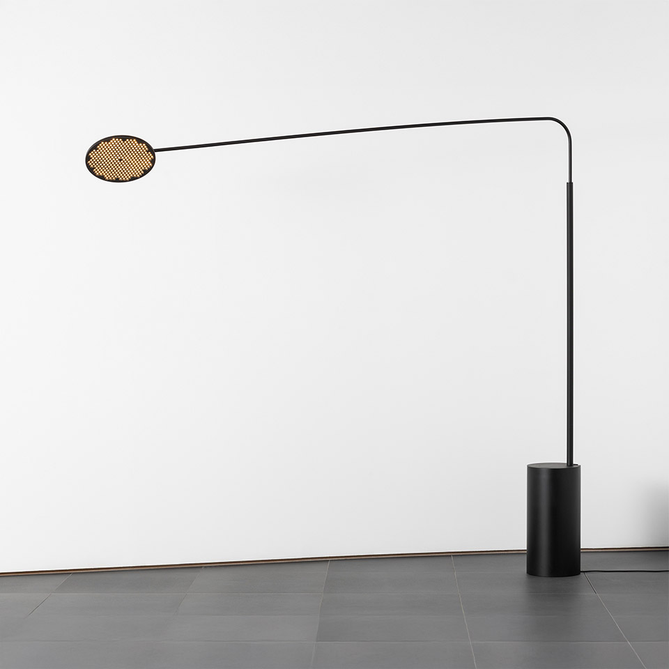 Artemide Helgoland floor lamp: black arched stem with cylindrical base, oval perforated gold diffuser extending horizontally