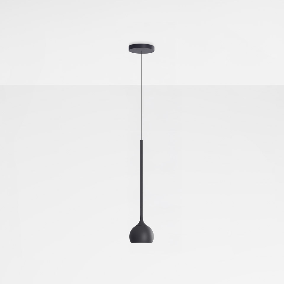 Artemide Ixa pendant lamp in black, featuring a slender stem and rounded bell-shaped shade, suspended from a circular ceiling canopy.