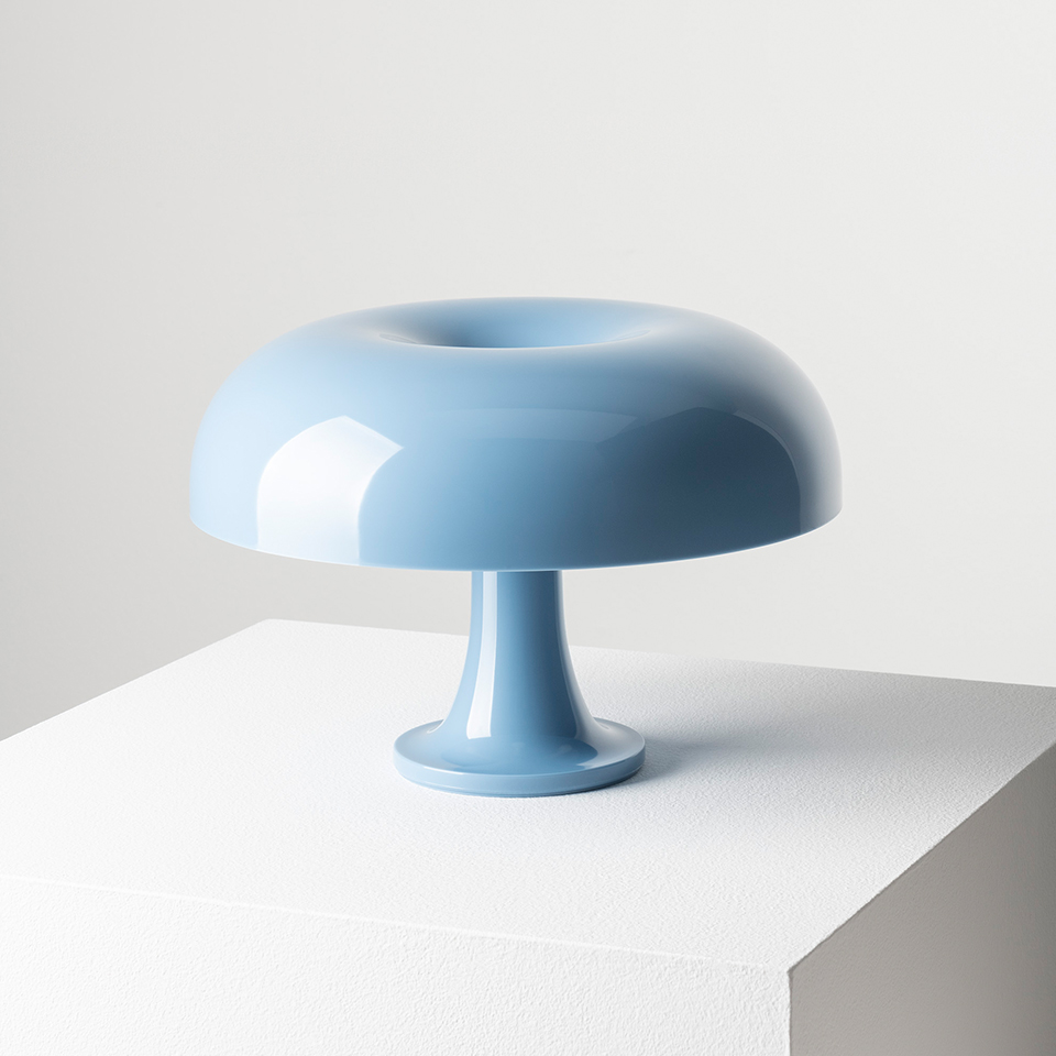 Artemide Nessino table lamp in light blue, featuring a glossy mushroom-shaped shade with a toroidal top on a slender pedestal base