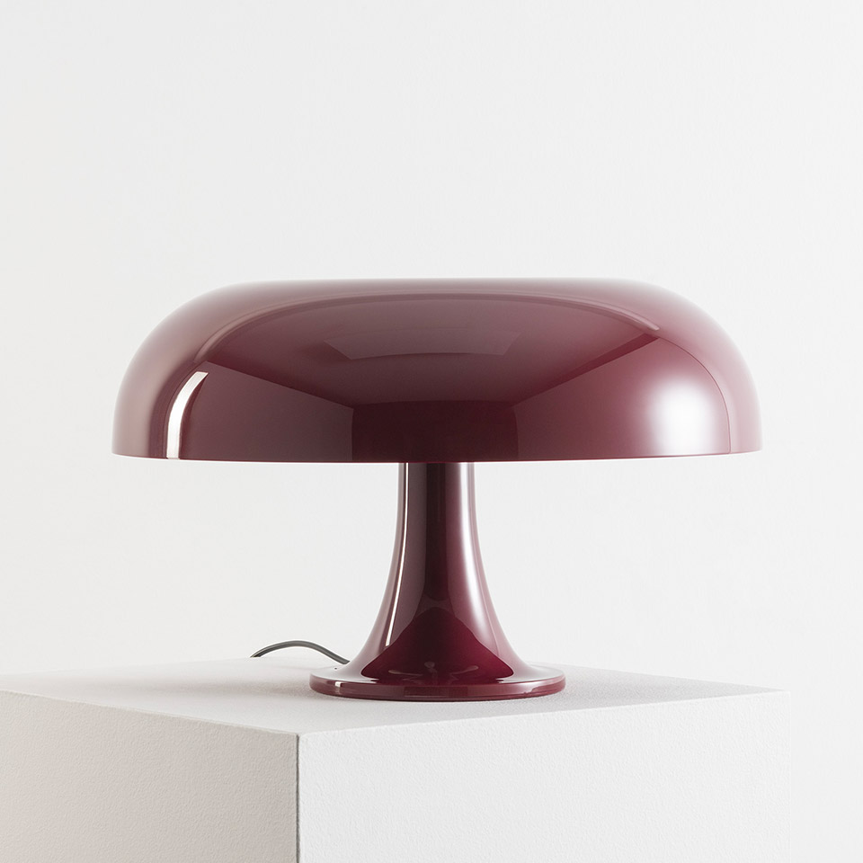 Artemide Nesso table lamp in burgundy red, featuring iconic mushroom-shaped glossy dome shade on a flared pedestal base