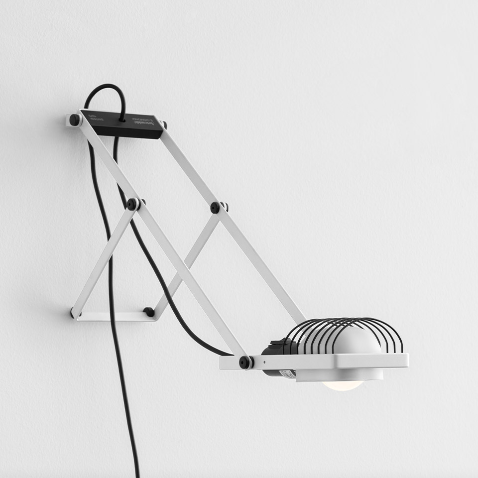 Artemide Sintesi wall lamp: white articulated scissor-arm structure with dome-shaped wire grid shade, mounted on wall with black cord