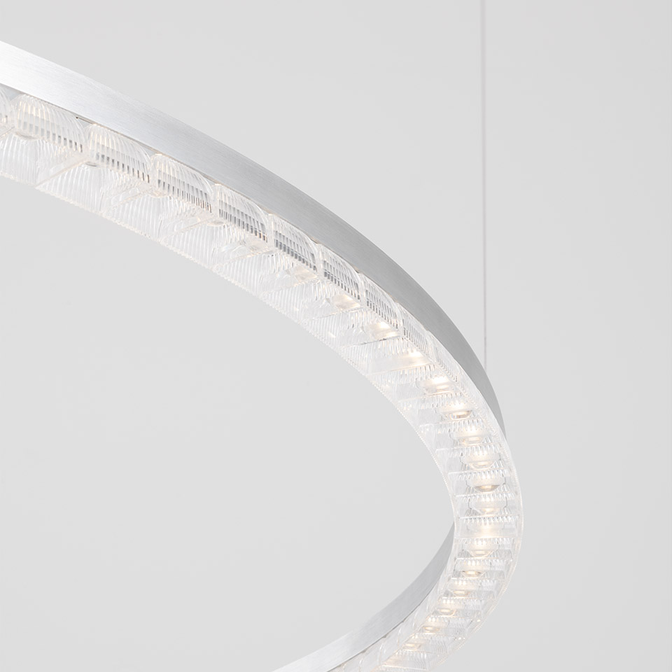 Artemide Somnĭum pendant lamp: close-up of circular aluminum ring with embedded prismatic crystal LED modules emitting warm white light