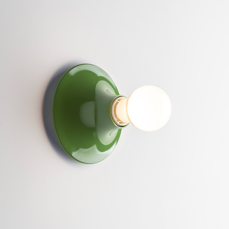 Artemide Teti wall lamp with glossy green dome-shaped base and exposed spherical white bulb mounted on white wall