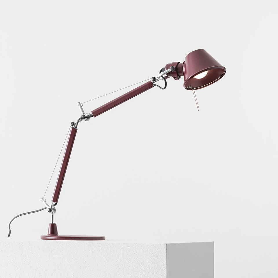 Artemide Tolomeo Micro Tavolo desk lamp in burgundy red, featuring articulated arm with tension cables and adjustable conical shade