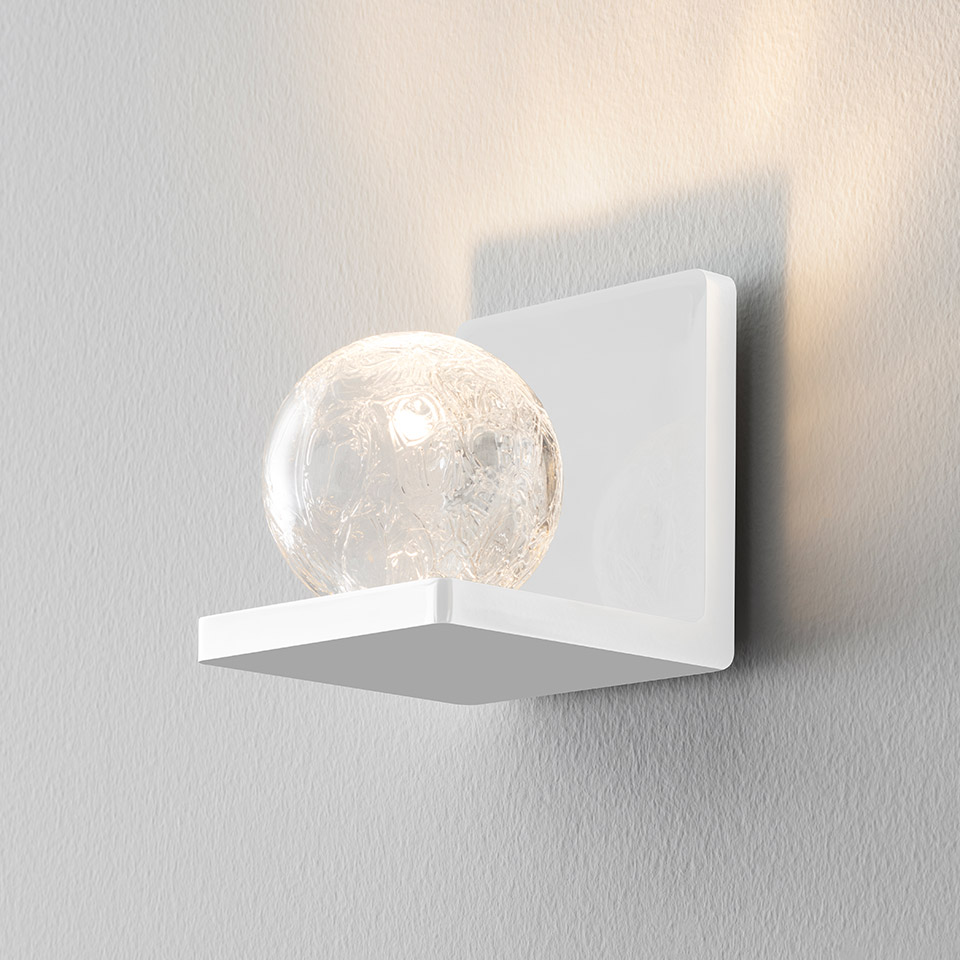 Artemide Ulrich und Diotima white wall sconce with crackled glass sphere resting on a square shelf bracket, casting warm light upward
