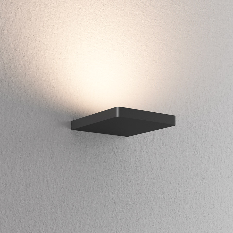 Artemide Ulrich und Diotima wall lamp, square dark metal body mounted on wall, emitting warm upward indirect light