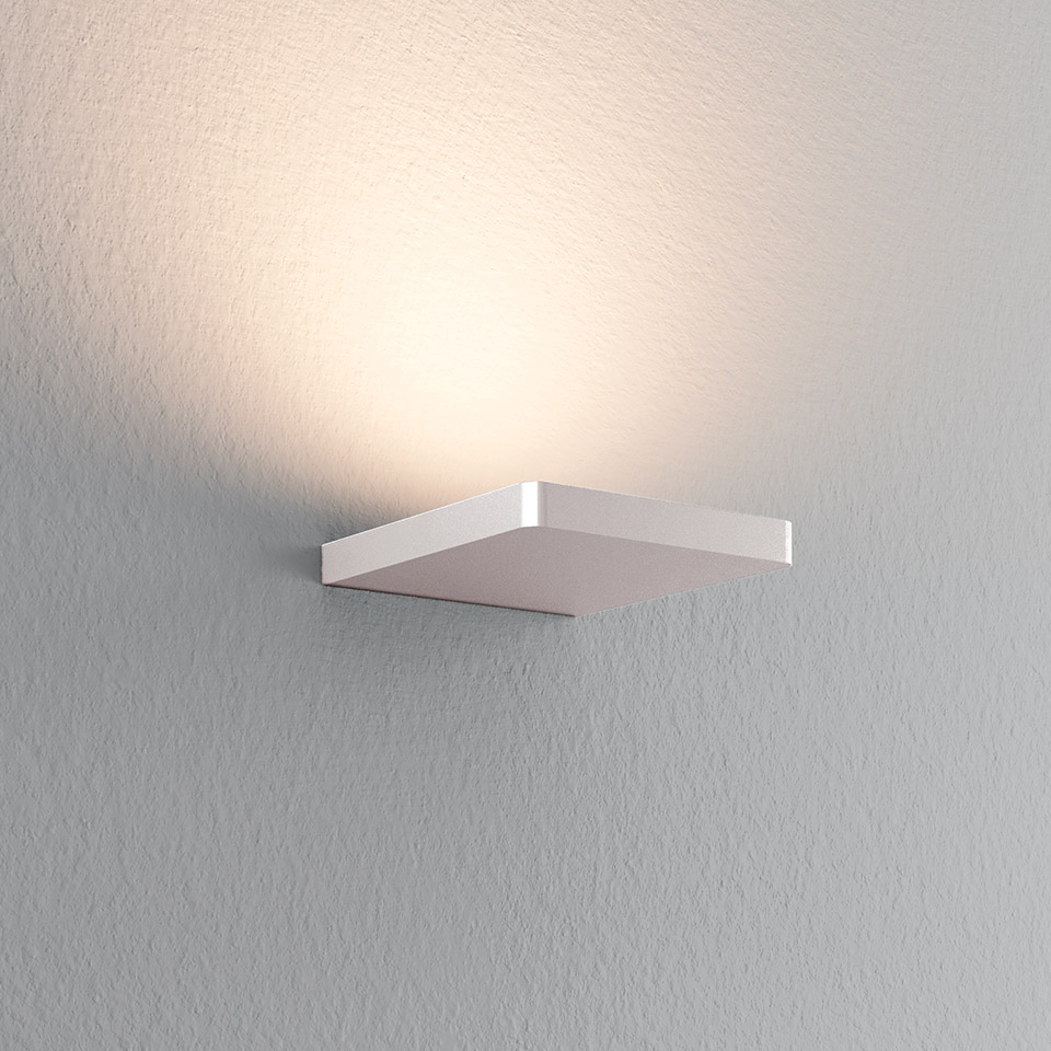 Artemide Ulrich und Diotima white square wall lamp emitting warm upward indirect light against a grey textured wall