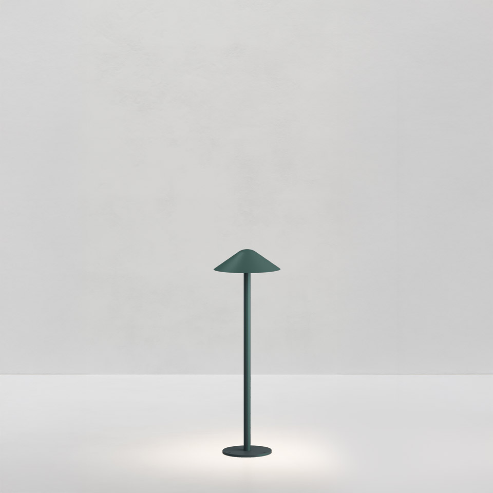 Artemide Vea Bollard table lamp in forest green, slender stem with wide conical shade, emitting soft downward light