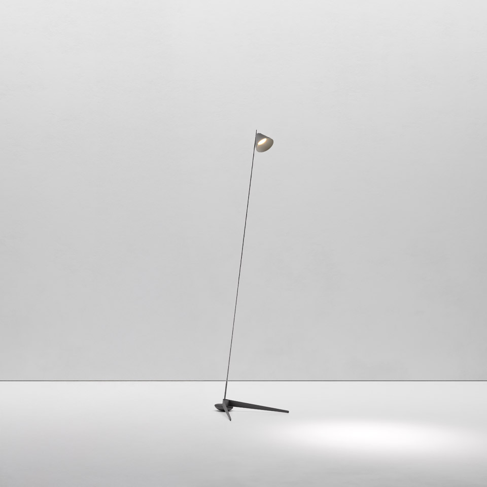 Artemide Vea floor lamp: slender stem on tripod base, small adjustable dome head, casting focused light downward