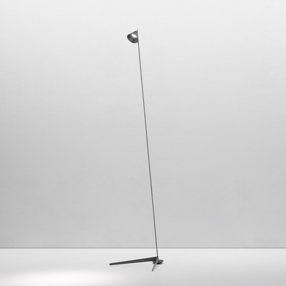Artemide Vea floor lamp: slender dark metal stem with small dome shade, minimalist tripod base, elegant and understated design