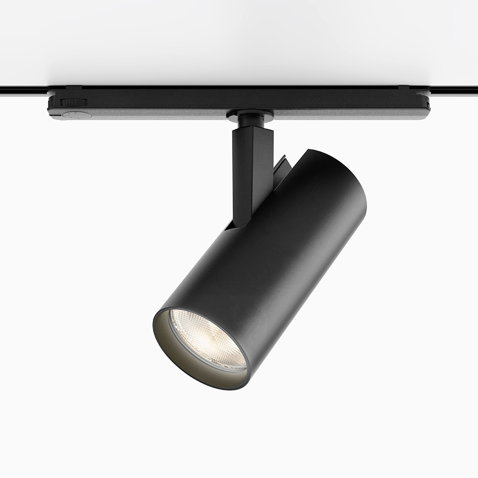 Artemide Vector Track 230V black cylindrical LED spotlight mounted on a track rail, tilted at an angle for directional lighting