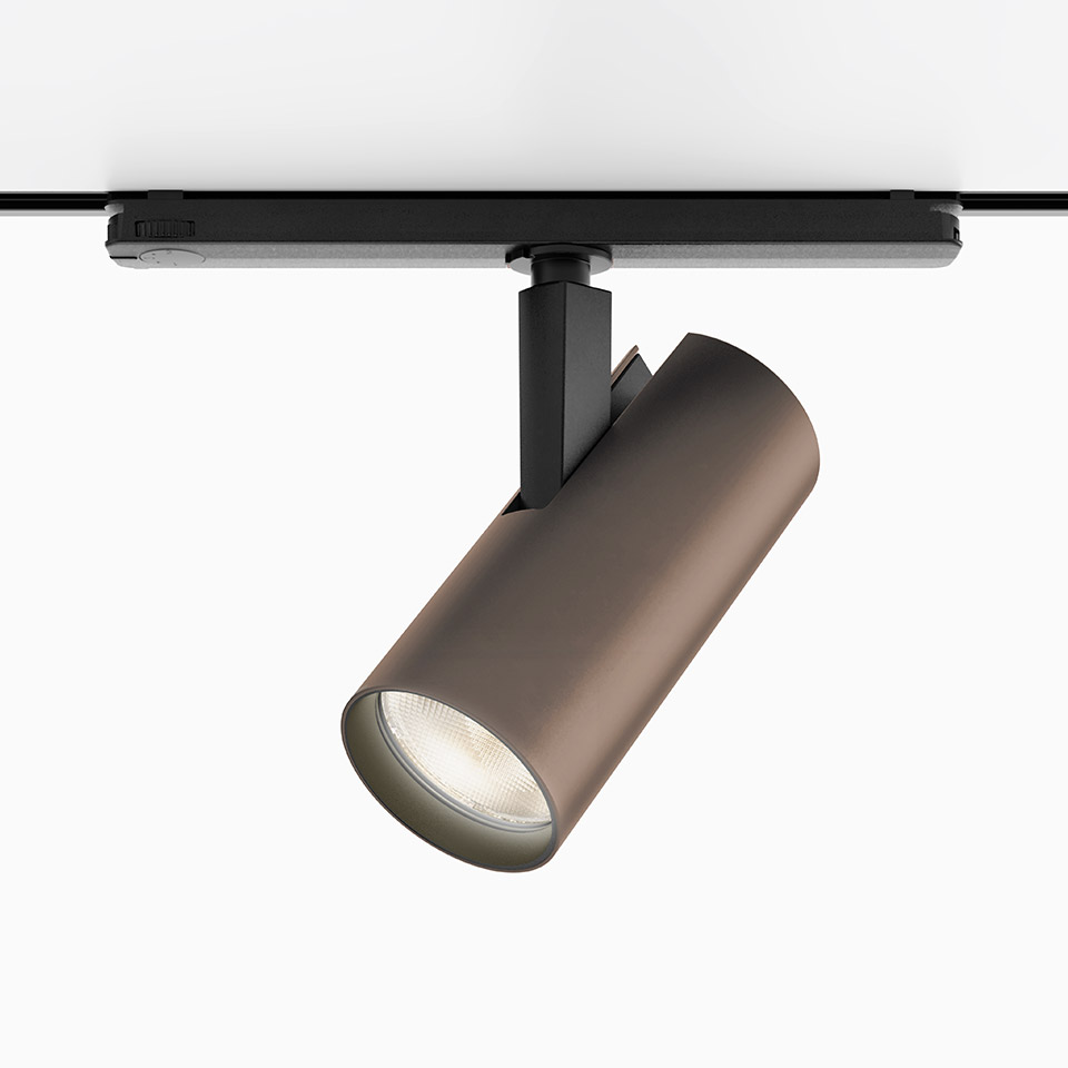 Artemide Vector Track 230V spotlight in bronze finish, cylindrical body mounted on black track rail, adjustable directional LED