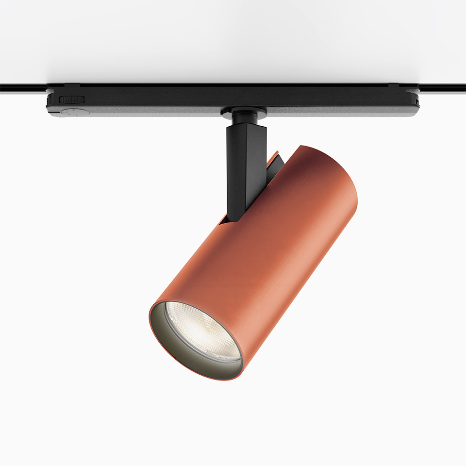 Artemide Vector Track 230V spotlight in terracotta red, cylindrical body on black track mount, adjustable LED spot