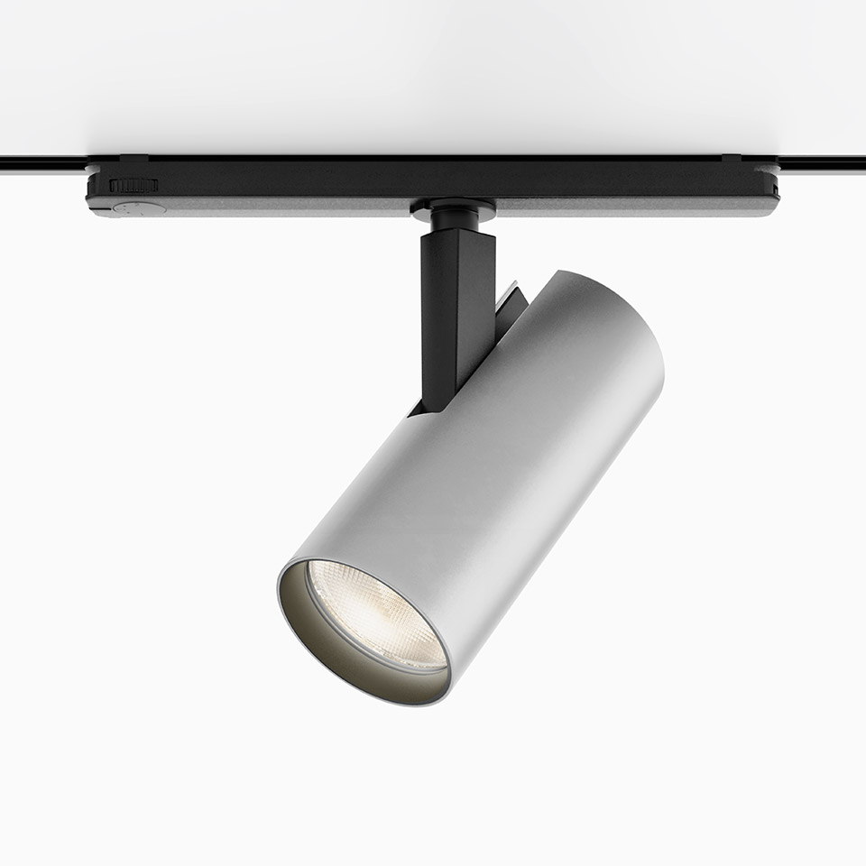 Artemide Vector Track 230V: cylindrical silver spotlight mounted on black track rail, adjustable head with LED light source
