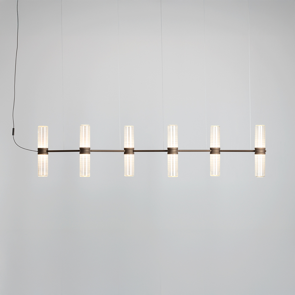 Artemide Zephyr pendant lamp: six vertical frosted glass cylinders mounted on a horizontal dark bronze bar, suspended by cables