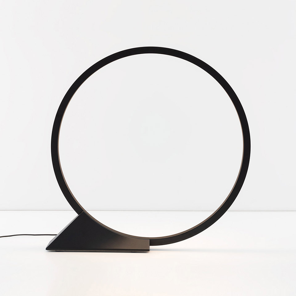 Artemide O table lamp: black circular LED ring on a triangular base, minimalist geometric design