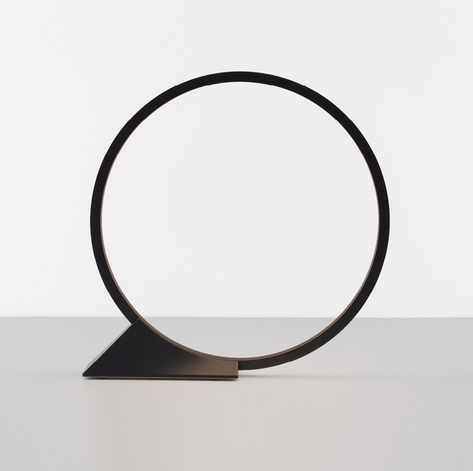 Artemide 'O' table lamp: minimalist black circular LED ring balanced on a triangular dark metal base