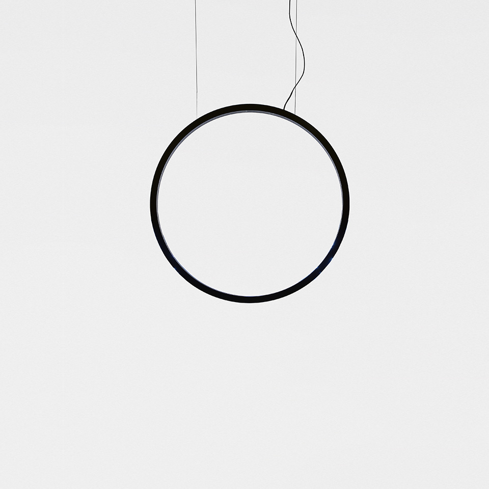 Artemide 'O' pendant lamp: minimalist black circular ring suspended by thin cables on white background