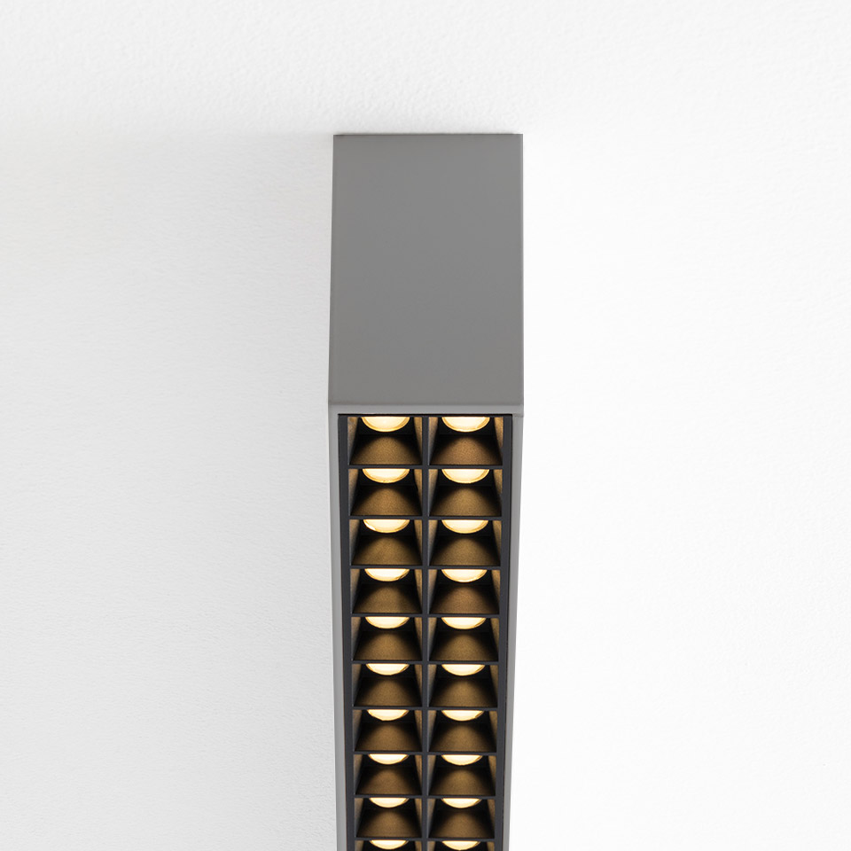 Artemide A.39 ceiling suspension lamp in grey, featuring two rows of microrefractive LED modules with warm golden reflectors