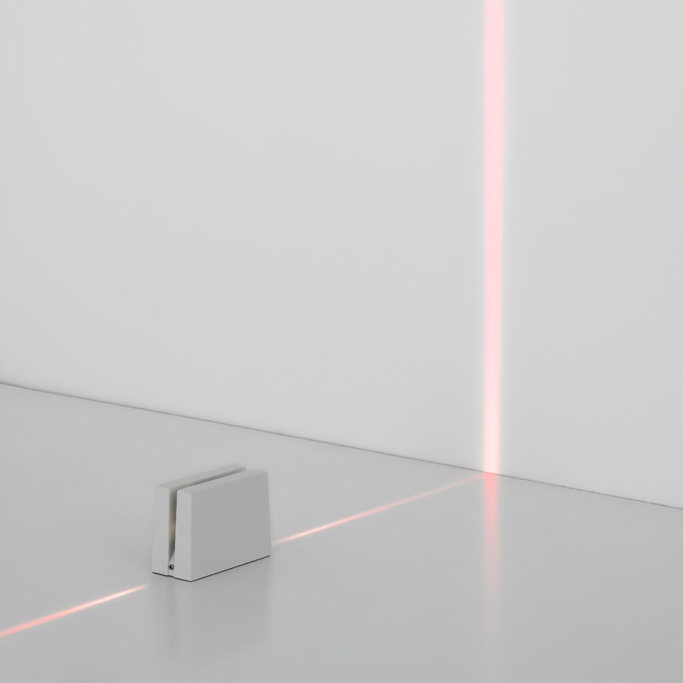 Antarktikós floor lamp by Artemide: compact white cube emitting a precise red light line across floor and up the wall