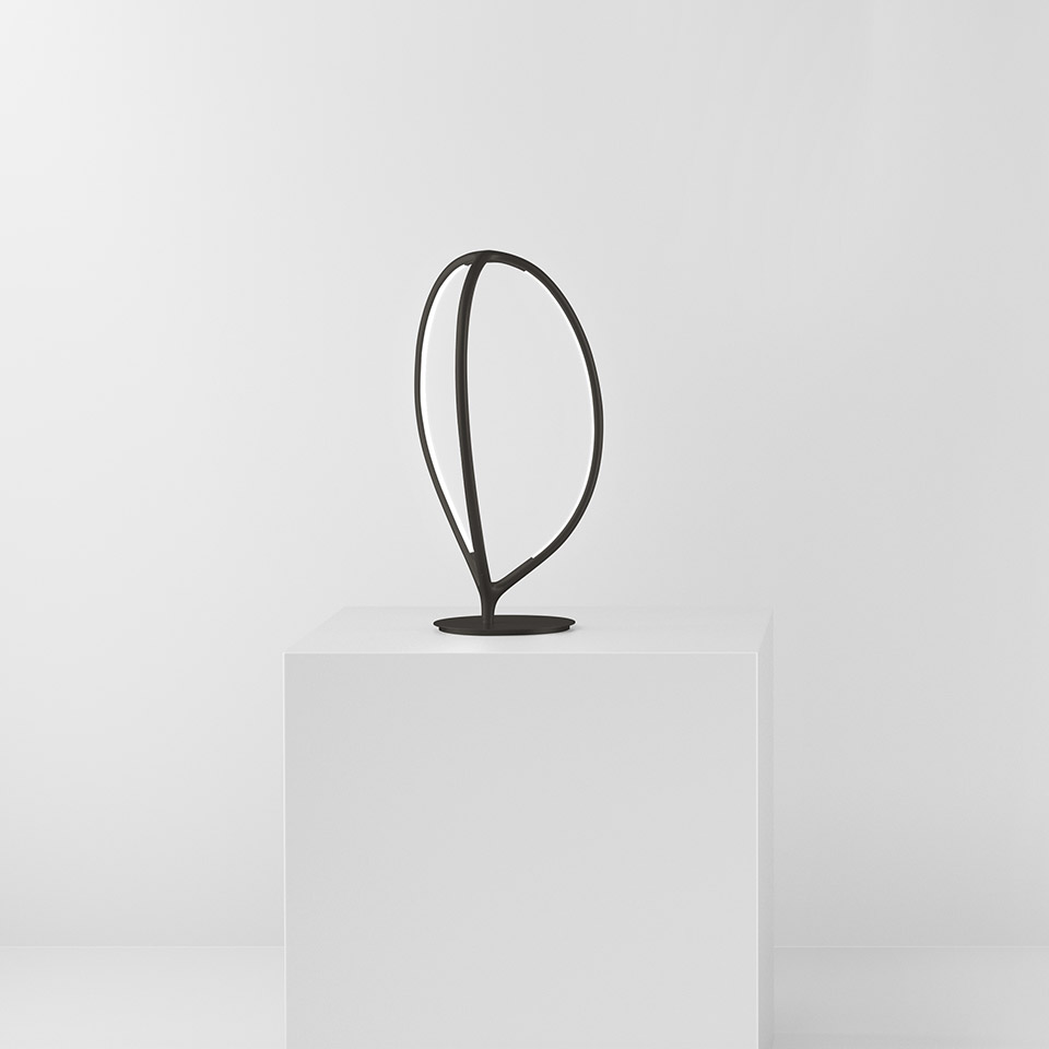 Artemide Arrival table lamp in black, featuring an organic leaf-shaped metal frame with integrated LED, on a round base