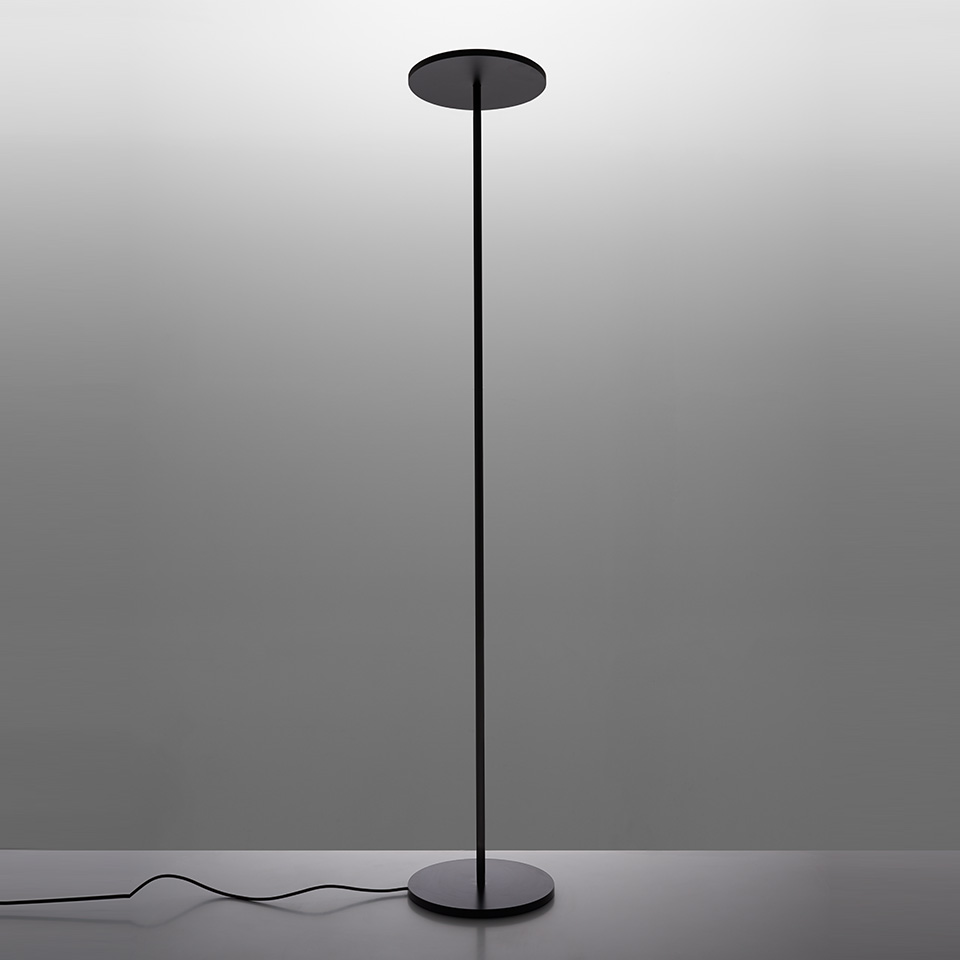 Artemide Athena floor lamp in black, featuring a slender stem with a flat circular disc top and round base.
