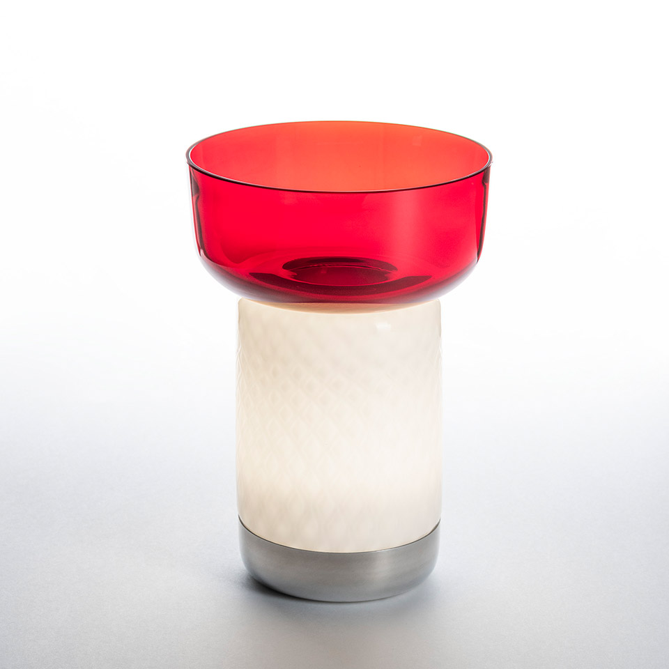 Artemide Bontà table lamp: cylindrical white diffuser on aluminum base topped with a translucent red glass bowl