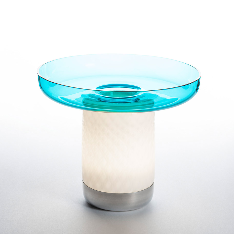 Artemide Bontà table lamp: glowing white cylindrical base with silver foot and large translucent turquoise glass dish on top