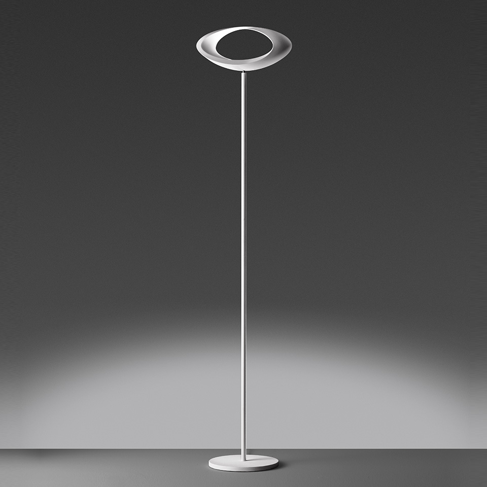 Artemide Cabildo floor lamp: tall slim white stem with circular disc-shaped diffuser on round base, emitting soft ambient light