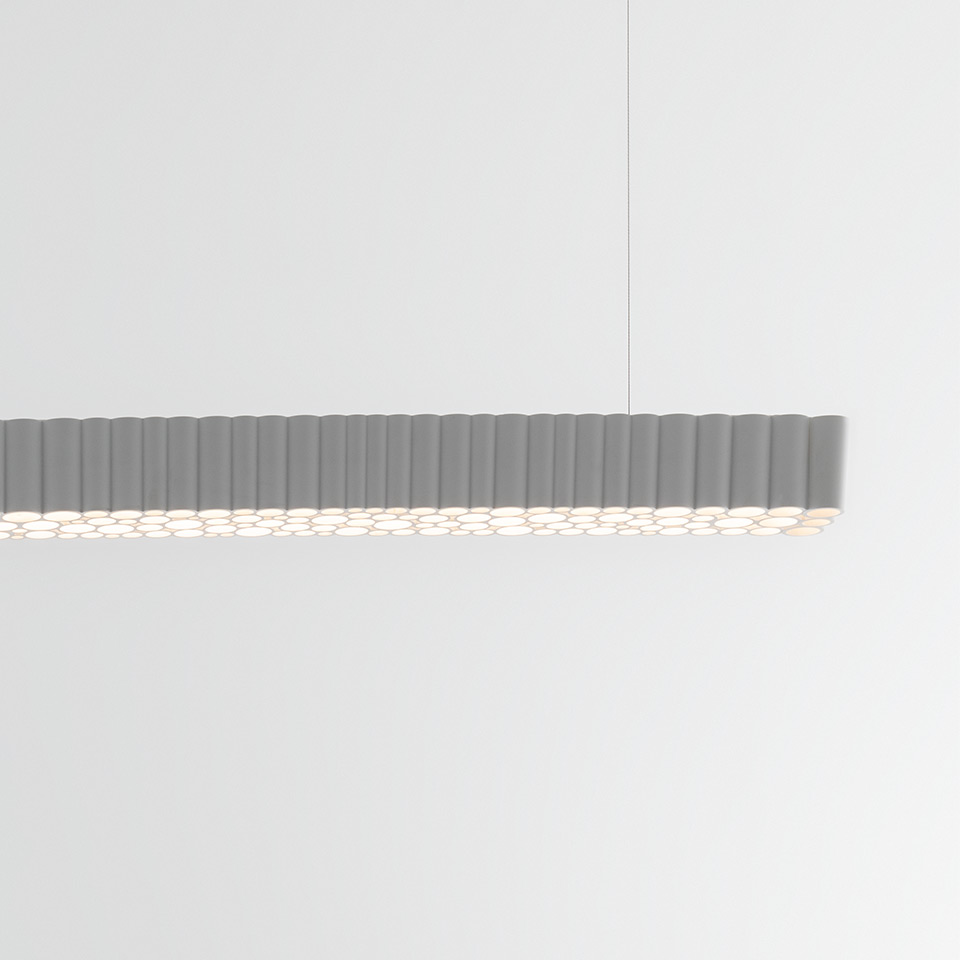 Artemide Calipso Linear System pendant lamp: elongated grey fixture with repeated cylindrical diffusers emitting soft downward light