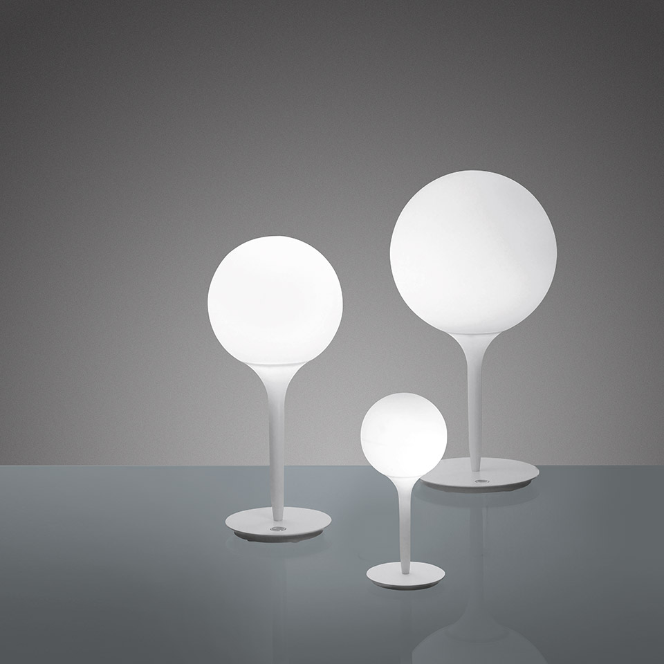 Three Artemide Castore Tavolo table lamps in white, featuring opal glass spheres on slender stems, displayed in small, medium, and large sizes.